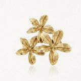 Bague en acier inoxydable doré, composée de trois fleurs aux pétales sculptés et texturés.
