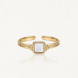 Bague ajustable en acier inoxydable doré, ornée d'une nacre carrée centrale et de détails perlés sur le corps.