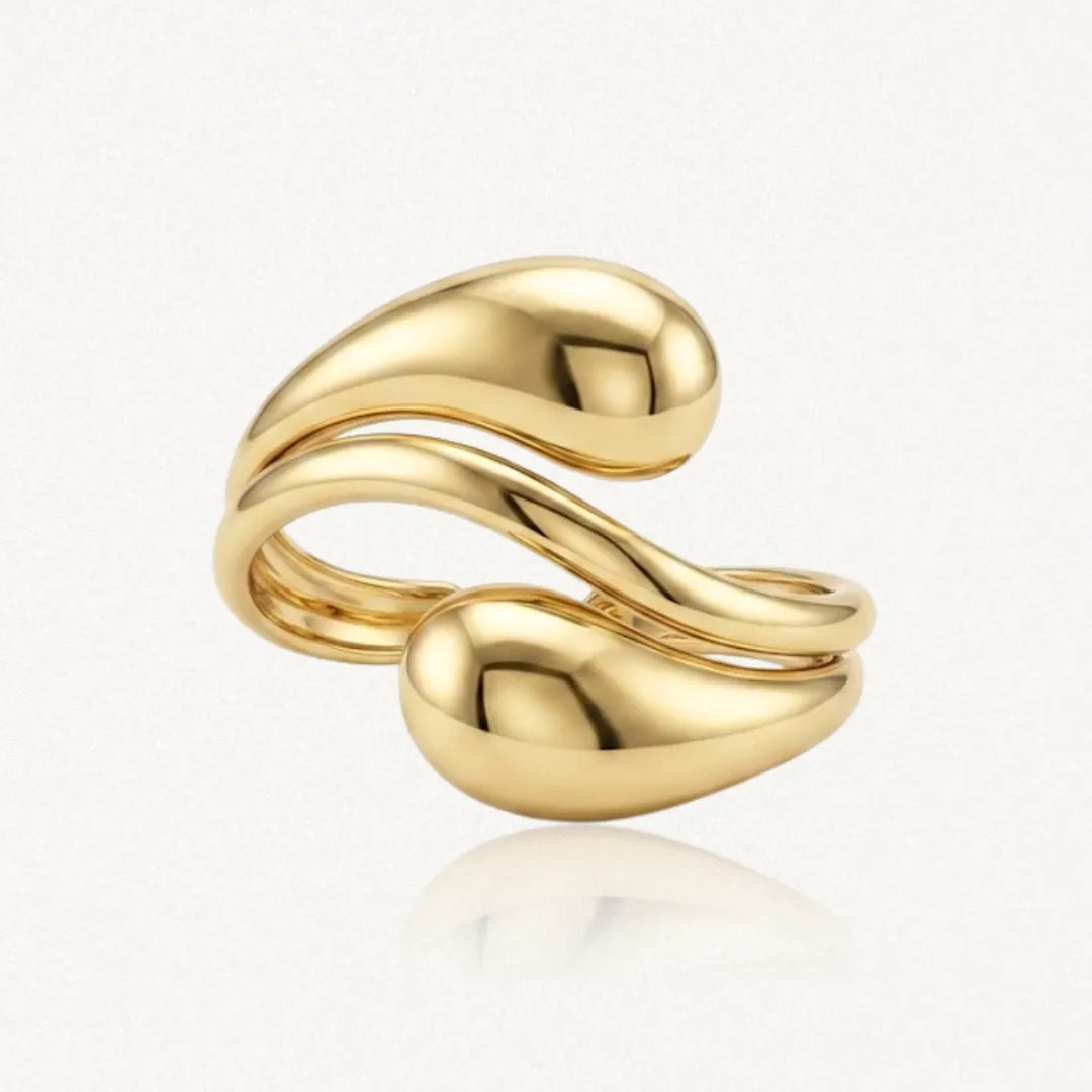 Bague ajustable en acier inoxydable doré. Son design épuré est composé de deux bandes ondulées finissant en gouttes d'eau
