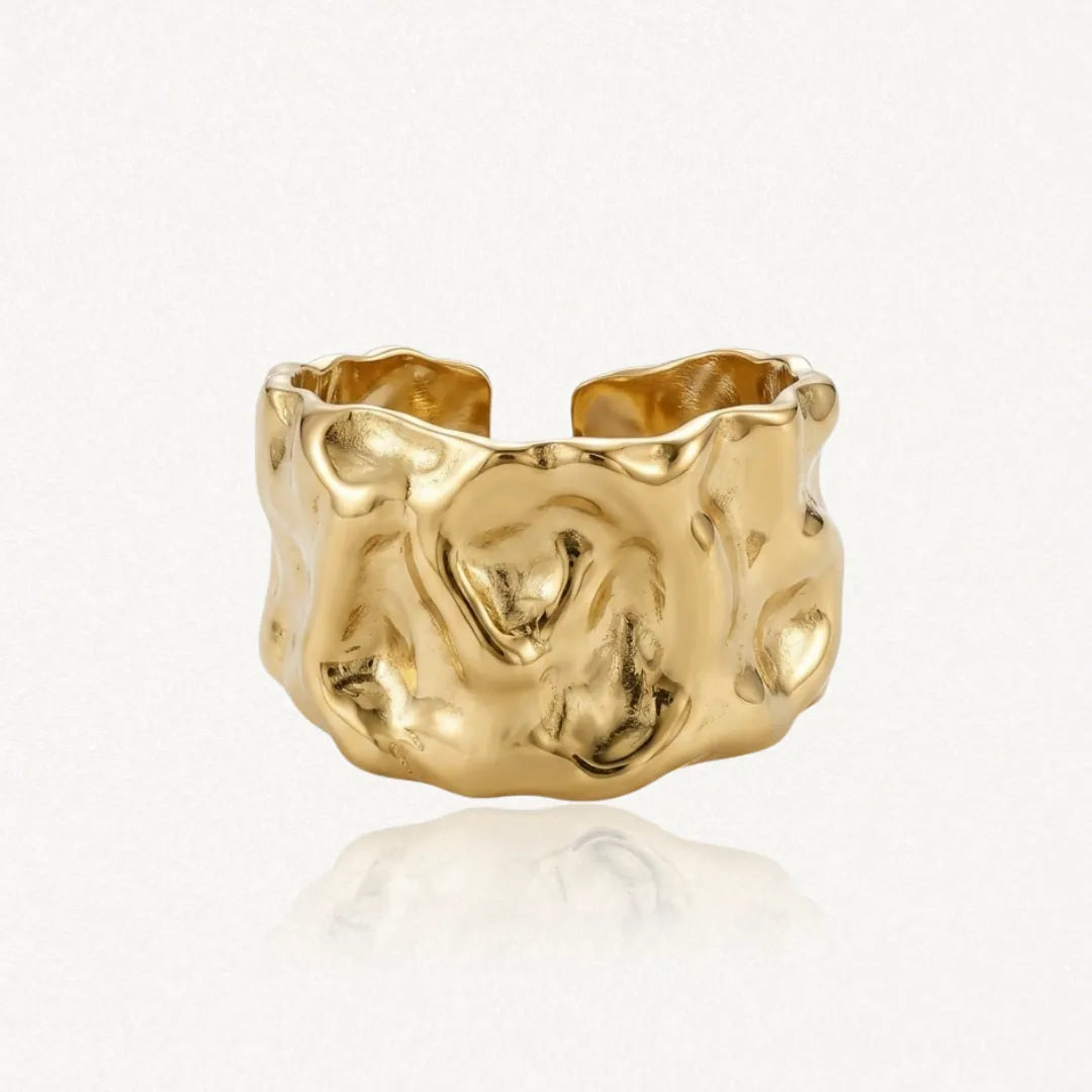 Bague large, ouverte, en acier inoxydable dore, à l'aspect froissé.