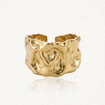 Bague large, ouverte, en acier inoxydable dore, à l'aspect froissé.