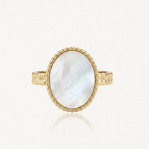 Bague en acier inoxydable doré, avec une nacre ovale irisée. Le serti est perlé et l'anneau martelé.