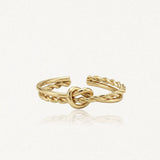 Bague ajustable en acier inoxydable doré, avec deux anneaux torsadés formant un nœud central.