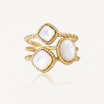 Bague dorée avec trois pierres de nacre à facettes, deux carrées et une ovale, sur des anneaux perlés.