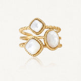 Bague dorée avec trois pierres de nacre à facettes, deux carrées et une ovale, sur des anneaux perlés.