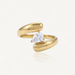 Bague ouverte en acier inoxydable doré, ornée d'un Zirconium taillé en poire et maintenu par trois griffes.