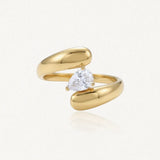 Bague ouverte en acier inoxydable doré, ornée d'un Zirconium taillé en poire et maintenu par trois griffes.