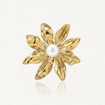 Bague en acier inoxydable doré, représentant une fleur à sept pétales texturés avec une perle blanche au centre.