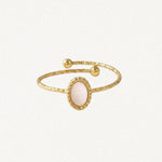 Bague ajustable en acier inoxydable doré texturé, avec nacre ovale rose pâle et deux billes aux extrémités.
