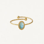 Bague ouverte en acier inoxydable doré. L'anneau martelé est orné d'une pierre naturelle ovale bleu-vert clair facetée et de
