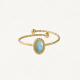 Bague ouverte en acier inoxydable doré. L'anneau martelé est orné d'une pierre naturelle ovale bleu-vert clair facetée et de