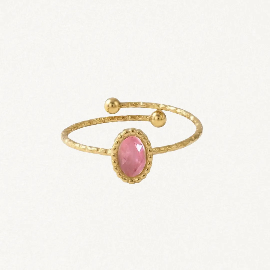 Bague ajustable en acier inoxydable dore, ornée d'une pierre naturelle rose ovale facettée sertie d'un rebord perlé, et