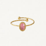 Bague ajustable en acier inoxydable dore, ornée d'une pierre naturelle rose ovale facettée sertie d'un rebord perlé, et