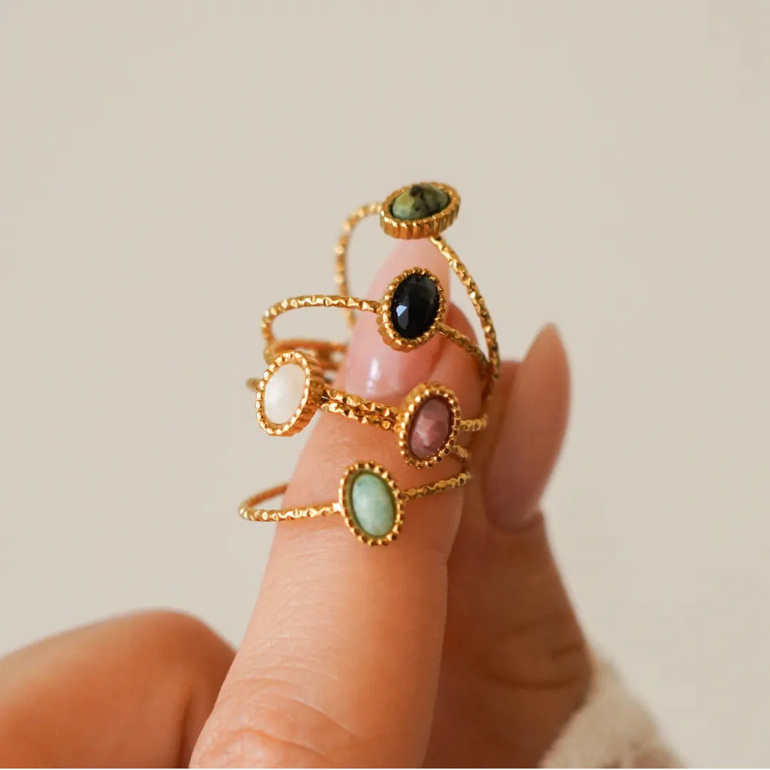 Pour les bagues : "Bague en acier inoxydable doré ornée d'une pierre naturelle ovale, sur un doigt, couleurs diverses." (111