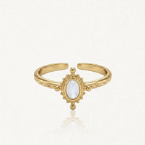 Bague ajustable en acier inoxydable doré, avec nacre ovale au centre, encadrée de motifs perlés. Bande gravée.