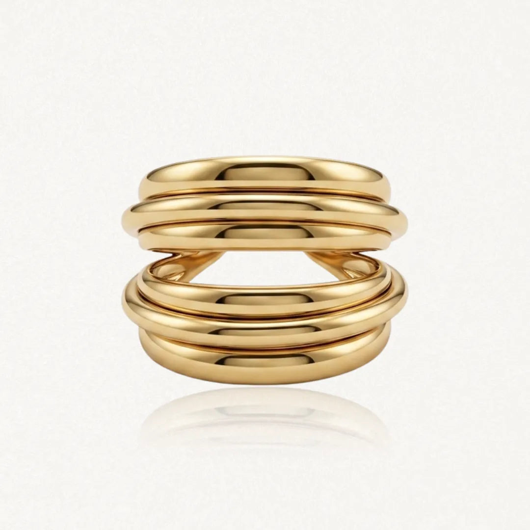 Bague en acier inoxydable doré, composée de six anneaux bombés parallèles séparés en son centre. Hauteur 1,80 cm.