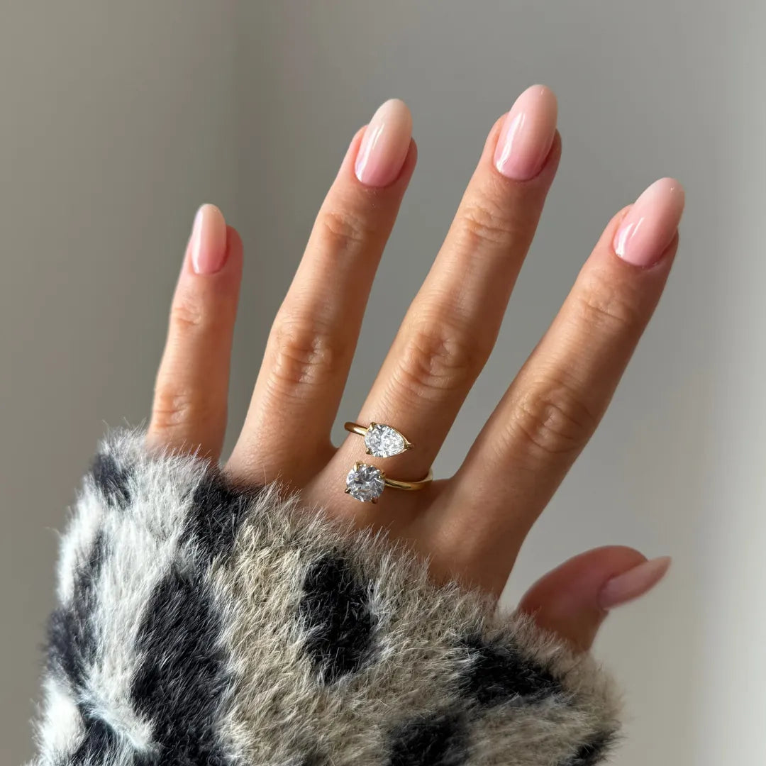 Bague toi et moi en acier inoxydable doré, ornée d'une pierre zirconium ronde et d'une pierre zirconium poire, portée sur une