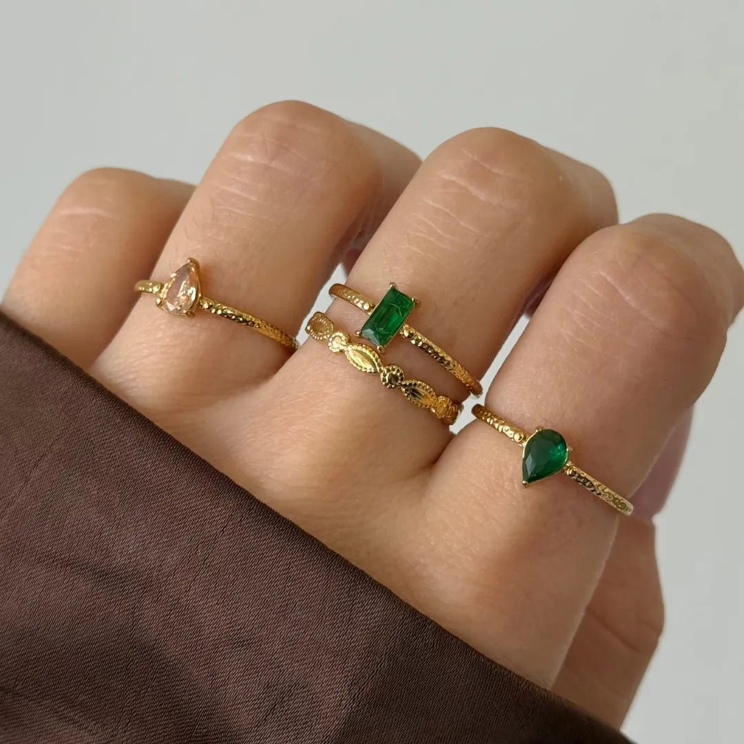 Bague Zelie en acier inoxydable doré avec un strass en zirconium vert en forme de poire porté sur un doigt