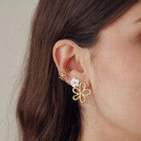 Boucles d'oreilles acier inoxydable dorées motifs fleurs portées: grande fleur ajourée, petite fleur blanche et mini fleur