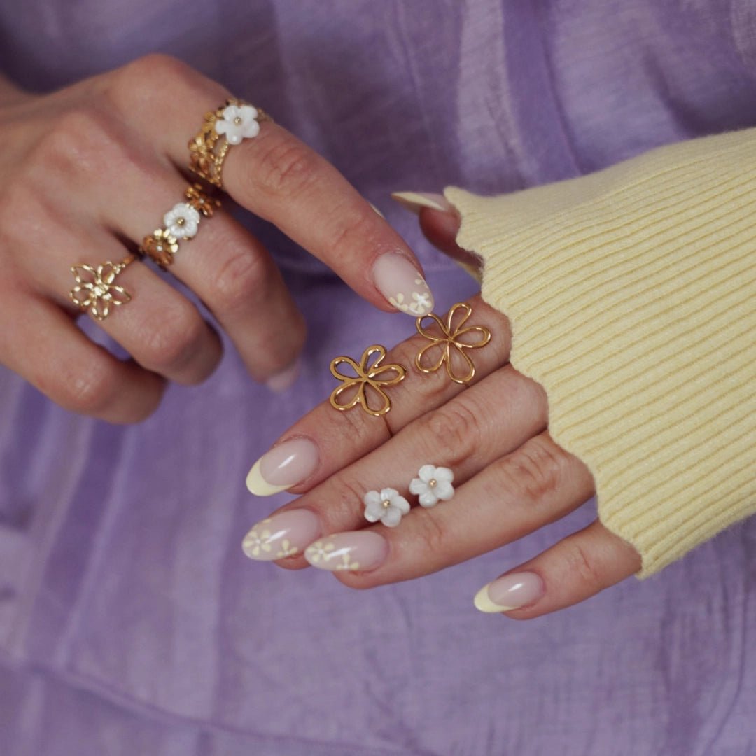Boucles d'oreilles en acier inoxydable: deux fleurs filaires dorées et deux petites fleurs blanches.
