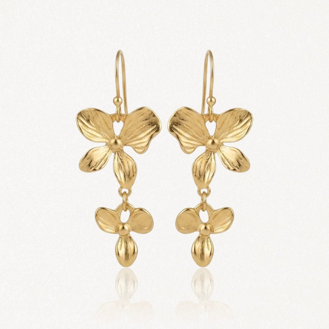 Boucles d'oreilles pendantes en acier inoxydable doré, avec motifs floraux superposés et goutte stylisée.