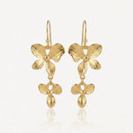 Boucles d'oreilles pendantes en acier inoxydable doré, avec motifs floraux superposés et goutte stylisée.