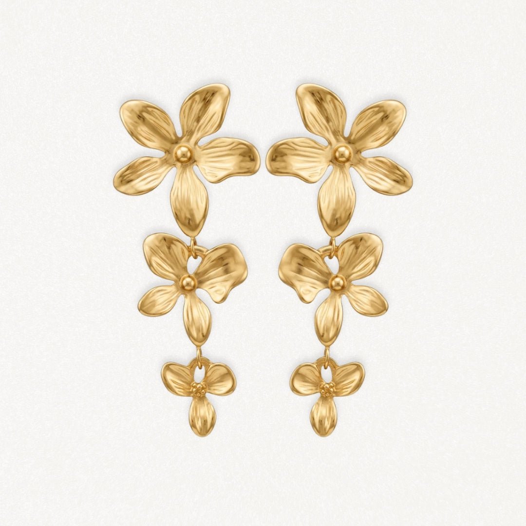 Boucles d'oreilles pendantes en acier inoxydable doré, design floral à trois fleurs texturées.