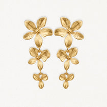Boucles d'oreilles pendantes en acier inoxydable doré, design floral à trois fleurs texturées.