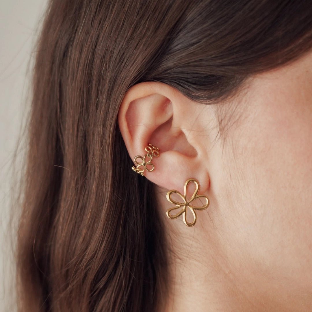 Boucles d'oreilles en acier inoxydable doré, fleur stylisée et manchette d'oreille florale sur oreille femme.