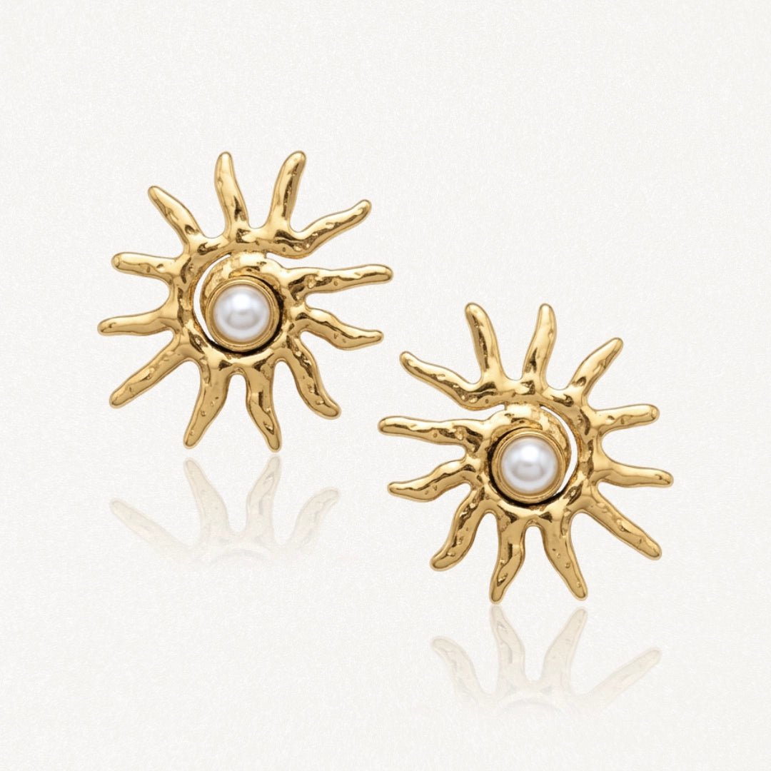 Boucles d'oreilles en acier inoxydable doré, forme soleil texturé avec perle nacrée centrale.