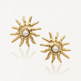 Boucles d'oreilles en acier inoxydable doré, forme soleil texturé avec perle nacrée centrale.