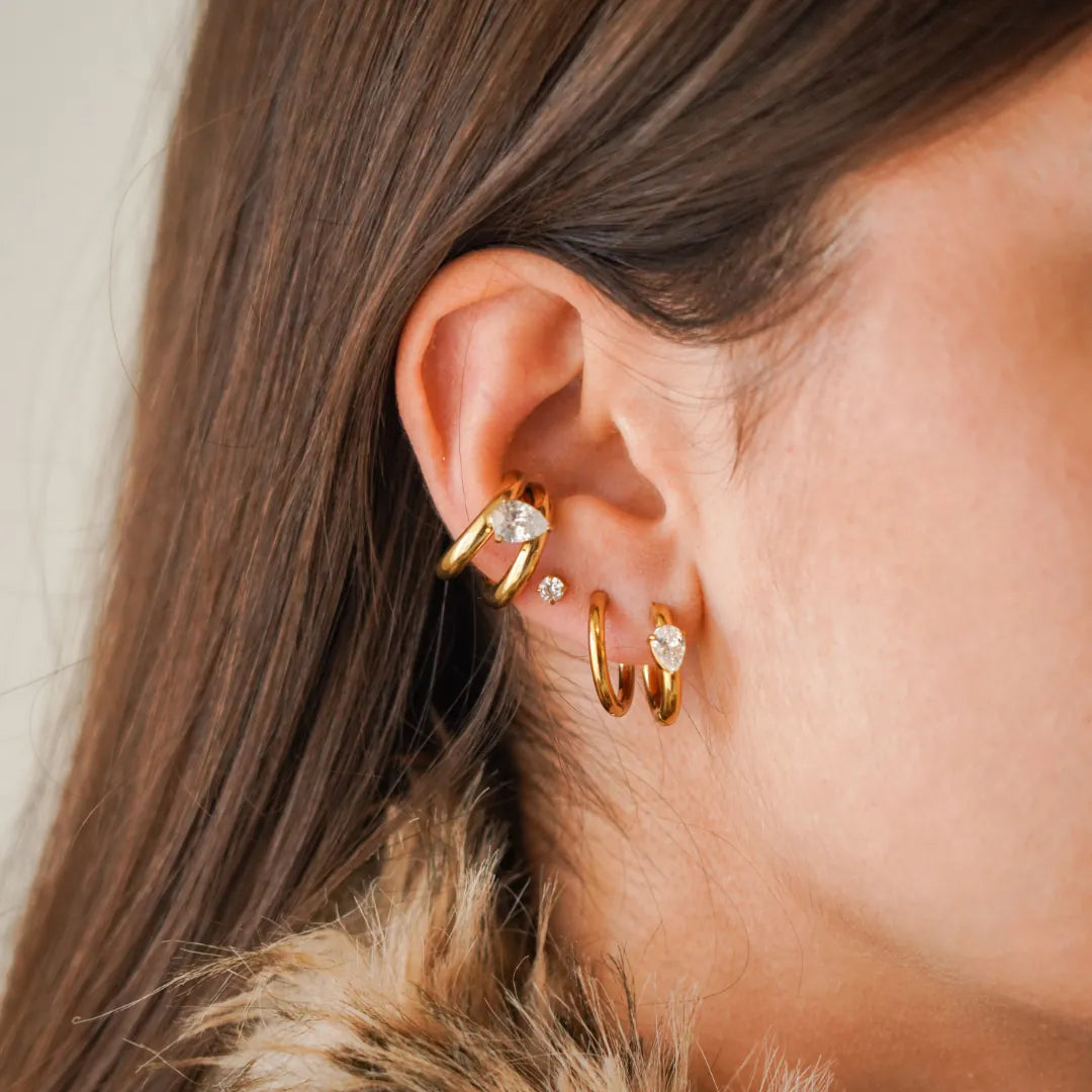 Oreille femme: manchette, puce et deux créoles en acier inoxydable doré. Manchette, une créole et puce avec éléments