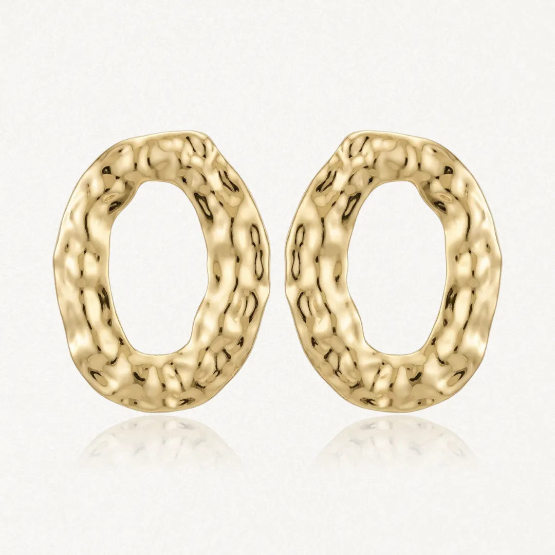 Paire de boucles d'oreilles ovales en acier inoxydable doré, avec une texture martelée et un relief organique.