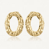Paire de boucles d'oreilles ovales en acier inoxydable doré, avec une texture martelée et un relief organique.