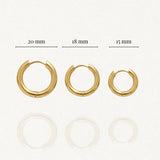 Trois boucles d'oreilles créoles dorées, diamètres 20 mm, 18 mm et 15 mm affichés, avec reflet léger.