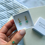 Boucles d'oreilles créoles (1,2cm) en acier inoxydable doré, breloques trèfles vertes translucides et bille dorée dans un