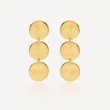 Deux boucles d'oreilles pendantes dorées, chacune composée de trois disques circulaires brillants et plats, reliés