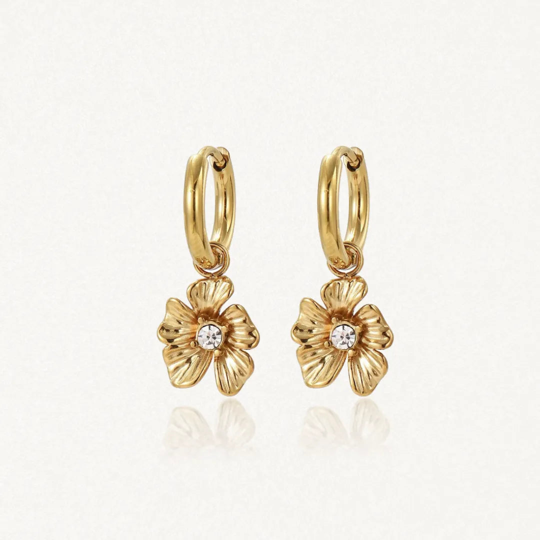 Paire de mini créoles en acier inoxydable doré avec pendentifs fleur sculptés, ornées de strass zirconium.
