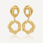 Paire de boucles d'oreilles pendantes dorées, à texture martelée, composées de deux formes organiques creuses reliées par un