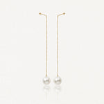 Paire de boucles d'oreilles pendantes à chaîne dorée avec fixation à boule et perle blanche ronde.