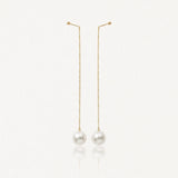 Paire de boucles d'oreilles pendantes à chaîne dorée avec fixation à boule et perle blanche ronde.