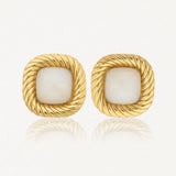 Paire de boucles d'oreilles carrées dorées, à bord torsadé, avec une pierre centrale blanche nacrée.