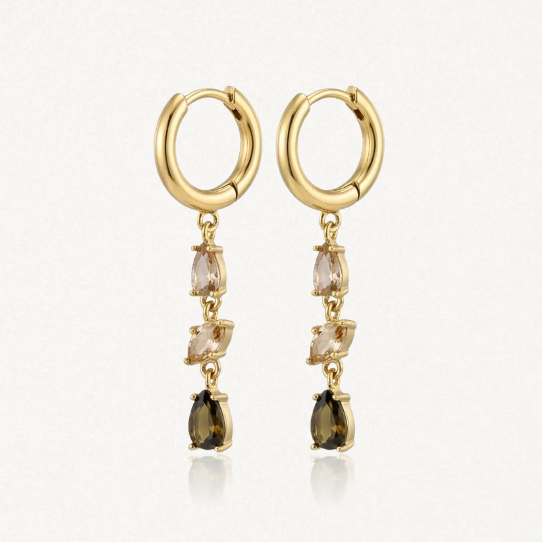 Boucles d'oreilles créoles pendantes en acier inoxydable doré, avec une cascade de zircons champagne et marron.