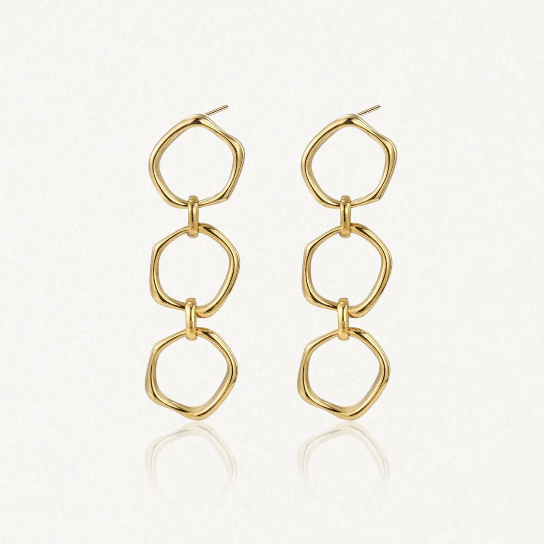 Boucles d'oreilles pendantes en acier inoxydable doré, composées de trois maillons irréguliers et brillants. Longueur 4 cm.