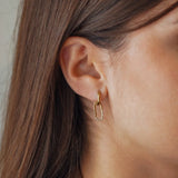 Boucles d'oreilles Kylie en acier inoxydable doré avec un anneau et un pendentif ovale orné de strass en zirconium