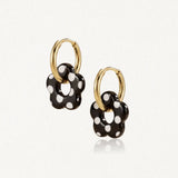 Boucles d'oreilles Lena en acier inoxydable doré avec des pendentifs en forme de fleur noire à pois blancs