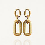 Boucles d'oreilles pendantes MAISON DE L'AMOUR composées d'un double maillon : un anneau lisse et un rectangle texturé en acier inoxydable doré.