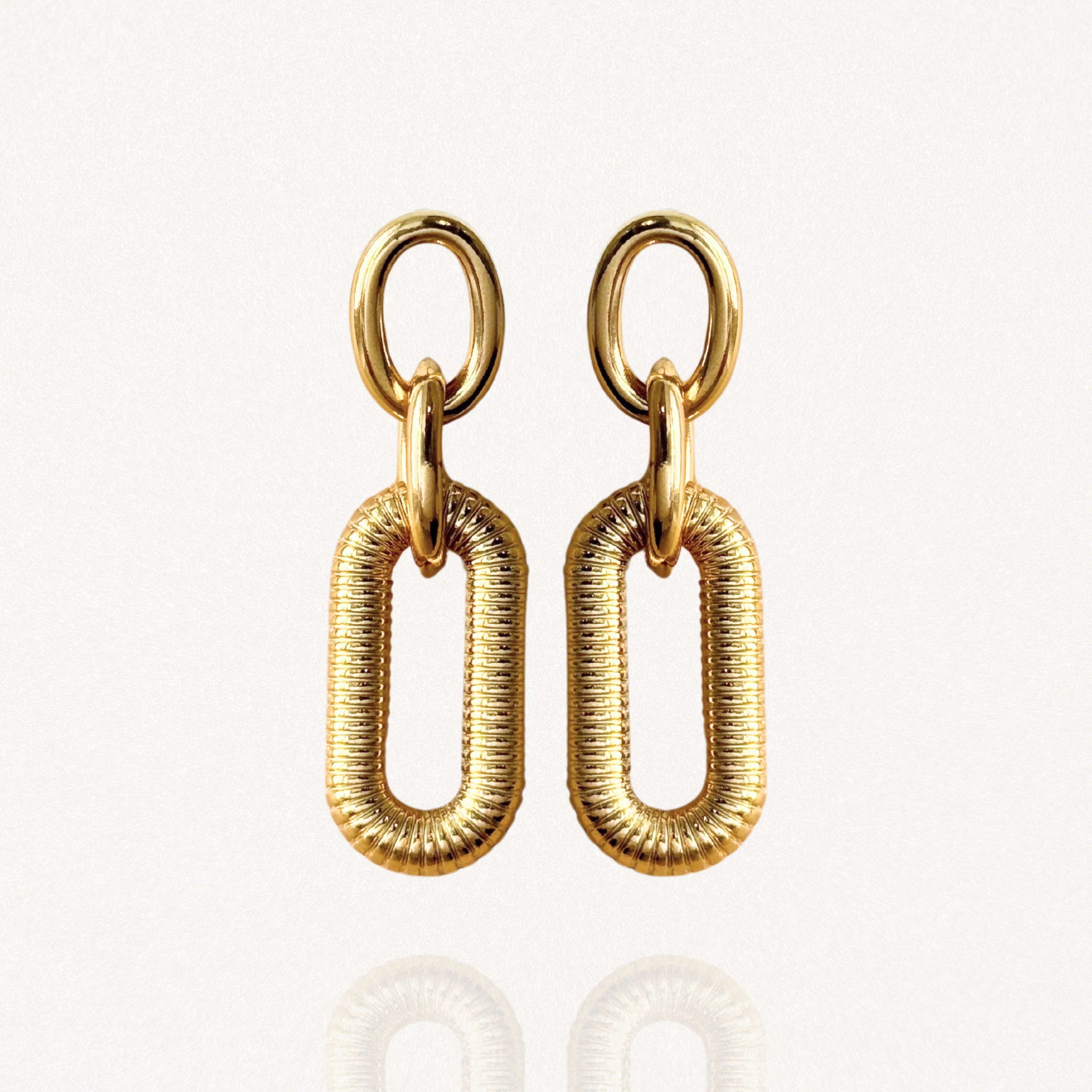 Boucles d'oreilles pendantes MAISON DE L'AMOUR composées d'un double maillon : un anneau lisse et un rectangle texturé en acier inoxydable doré.