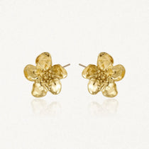 Paire de puces d'oreilles fleurs de cerisier en acier inoxydable doré, aux pétales texturés et centre granuleux.
