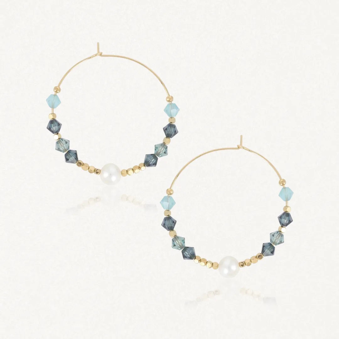 Deux boucles d'oreilles créoles en acier inoxydable doré avec des perles blanches, des pierres naturelles bleues et bleu